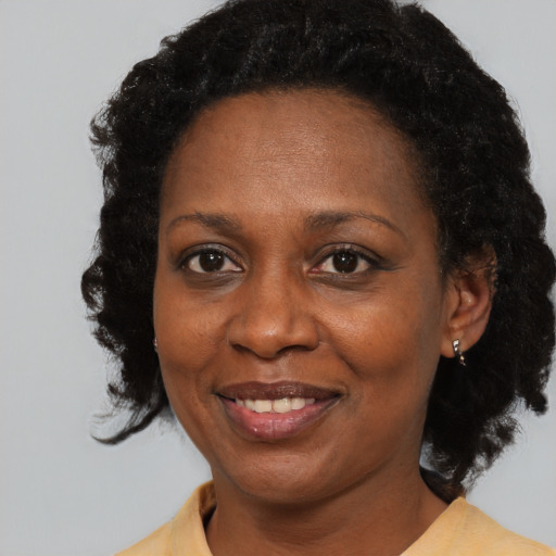 Joyful black adult female with medium  black hair and brown eyes