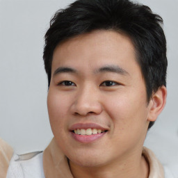 Joyful asian young-adult male with short  brown hair and brown eyes