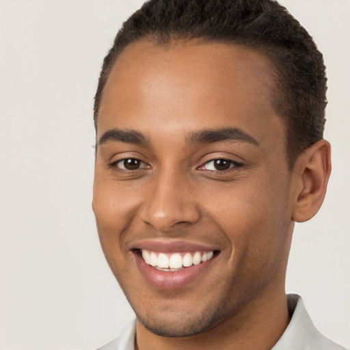 Joyful black young-adult male with short  brown hair and brown eyes