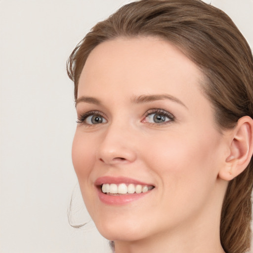 Joyful white young-adult female with long  brown hair and blue eyes