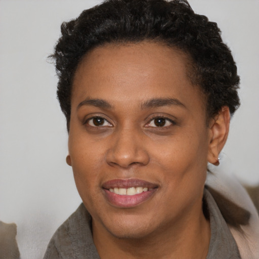 Joyful black young-adult female with short  brown hair and brown eyes