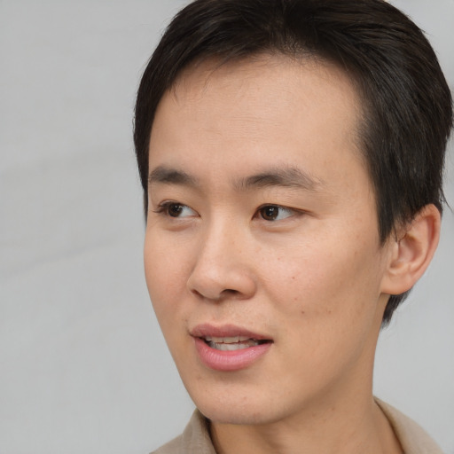Joyful asian young-adult male with short  brown hair and brown eyes