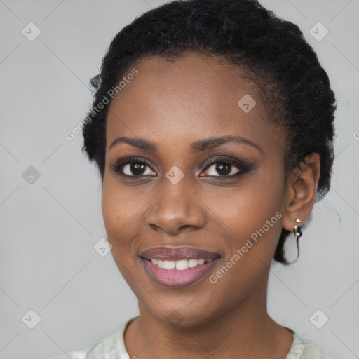 Joyful black young-adult female with short  black hair and brown eyes