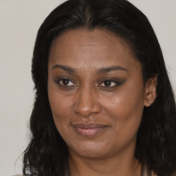 Joyful black adult female with long  brown hair and brown eyes