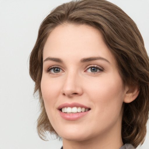 Joyful white young-adult female with medium  brown hair and green eyes