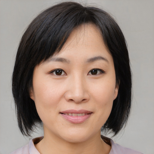Joyful asian young-adult female with medium  black hair and brown eyes
