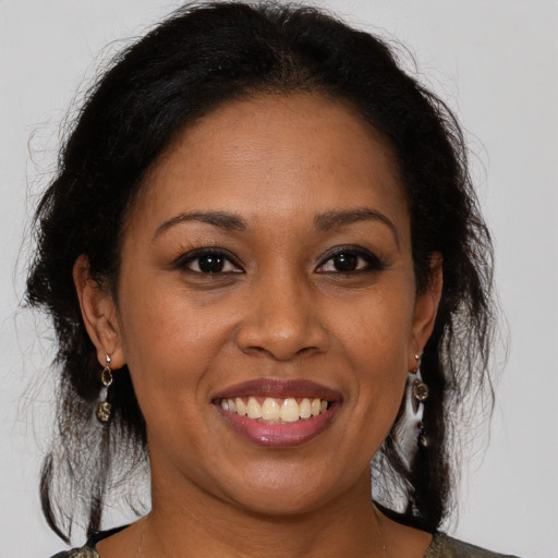 Joyful black adult female with medium  brown hair and brown eyes