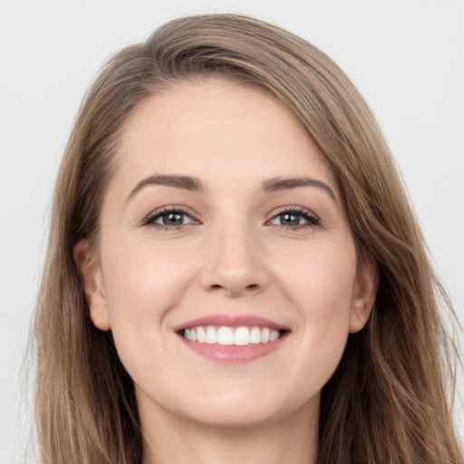 Joyful white young-adult female with long  brown hair and grey eyes