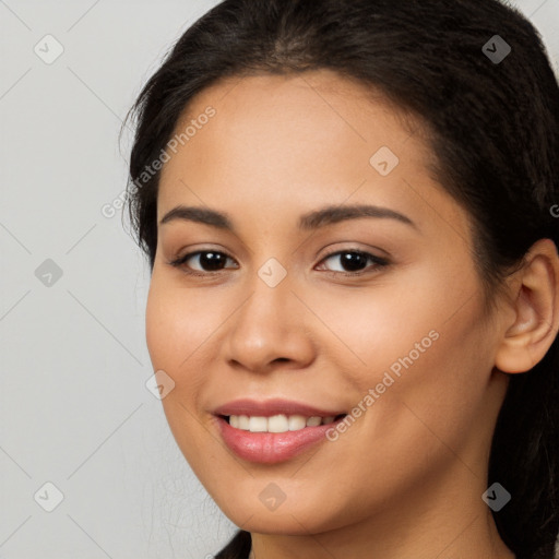 Joyful latino young-adult female with long  brown hair and brown eyes