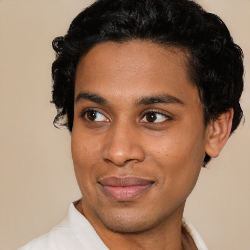 Joyful black young-adult male with short  brown hair and brown eyes
