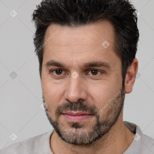 Joyful white adult male with short  black hair and brown eyes