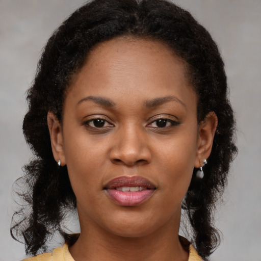 Joyful black young-adult female with medium  brown hair and brown eyes
