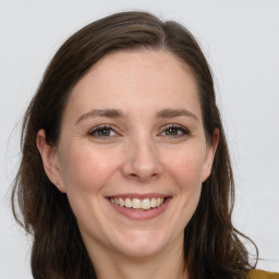 Joyful white adult female with long  brown hair and grey eyes