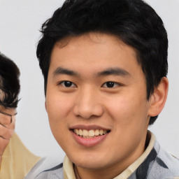 Joyful asian young-adult male with short  brown hair and brown eyes