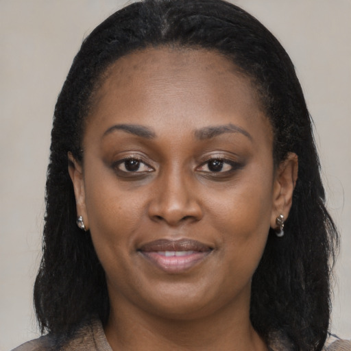 Joyful black young-adult female with long  brown hair and brown eyes
