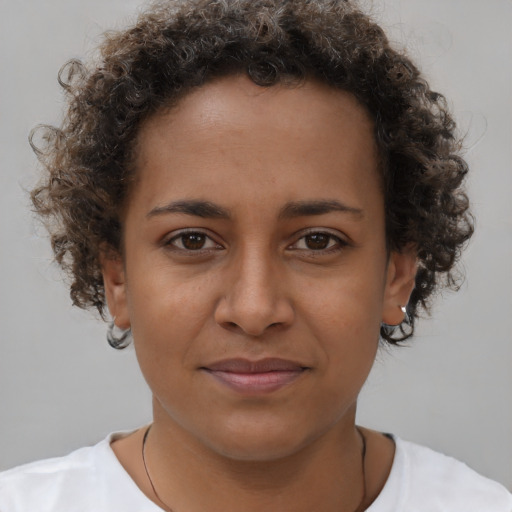Joyful black young-adult female with short  brown hair and brown eyes