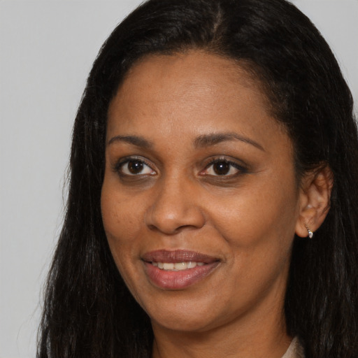 Joyful black young-adult female with long  brown hair and brown eyes