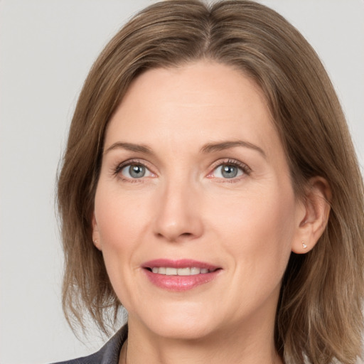 Joyful white adult female with medium  brown hair and grey eyes