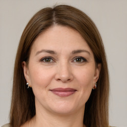 Joyful white adult female with long  brown hair and brown eyes