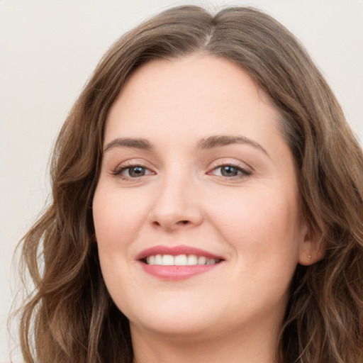 Joyful white young-adult female with long  brown hair and green eyes