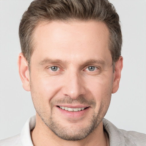 Joyful white adult male with short  brown hair and grey eyes