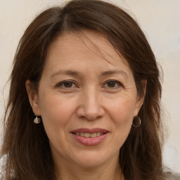 Joyful white adult female with long  brown hair and brown eyes