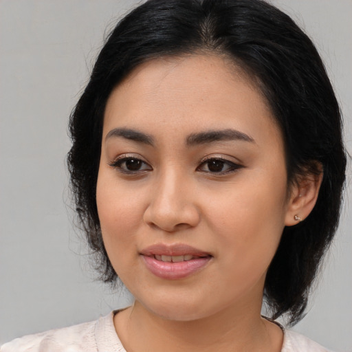 Joyful asian young-adult female with medium  black hair and brown eyes