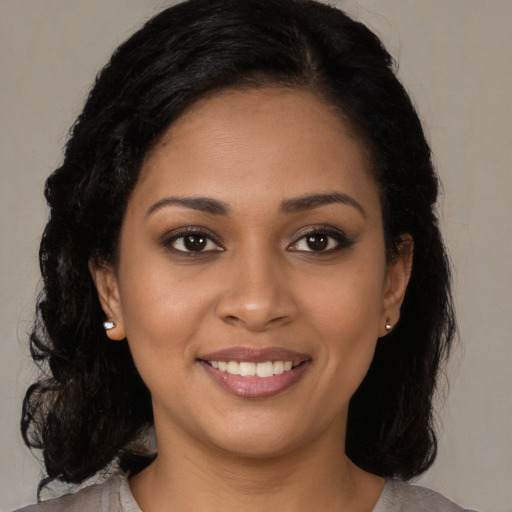 Joyful black young-adult female with long  brown hair and brown eyes