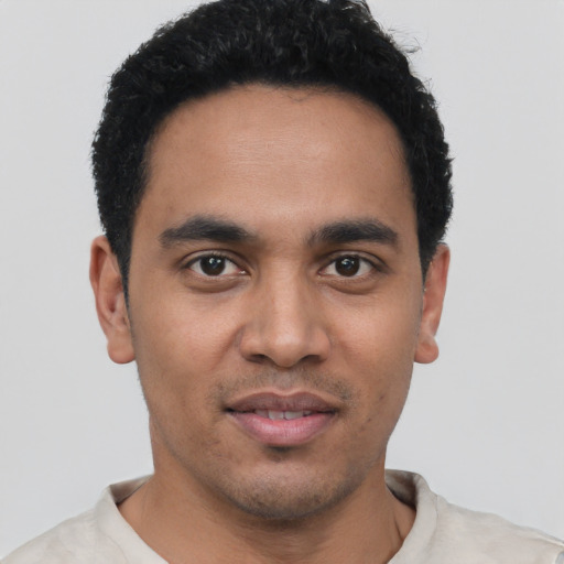 Joyful latino young-adult male with short  black hair and brown eyes