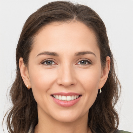 Joyful white young-adult female with long  brown hair and brown eyes