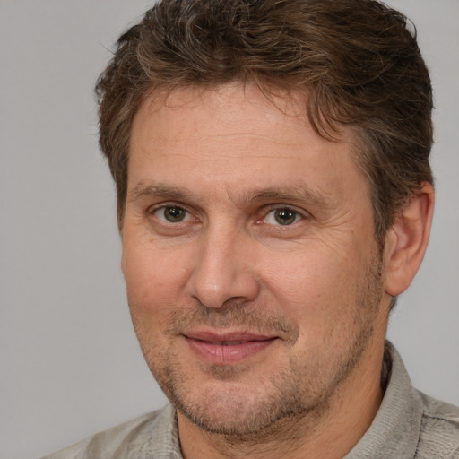 Joyful white adult male with short  brown hair and brown eyes