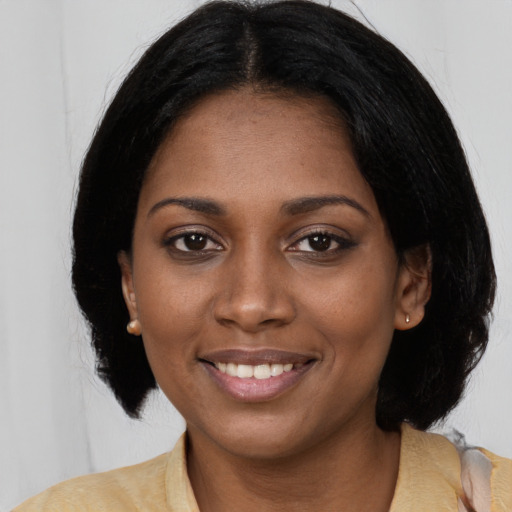 Joyful black young-adult female with medium  black hair and brown eyes