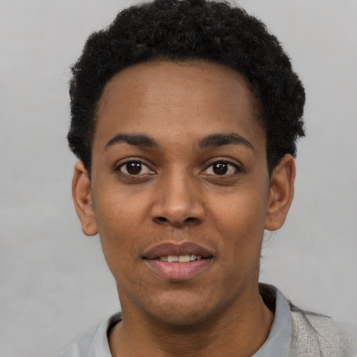 Joyful black young-adult female with short  black hair and brown eyes