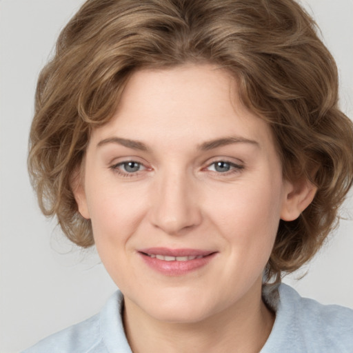 Joyful white young-adult female with medium  brown hair and blue eyes