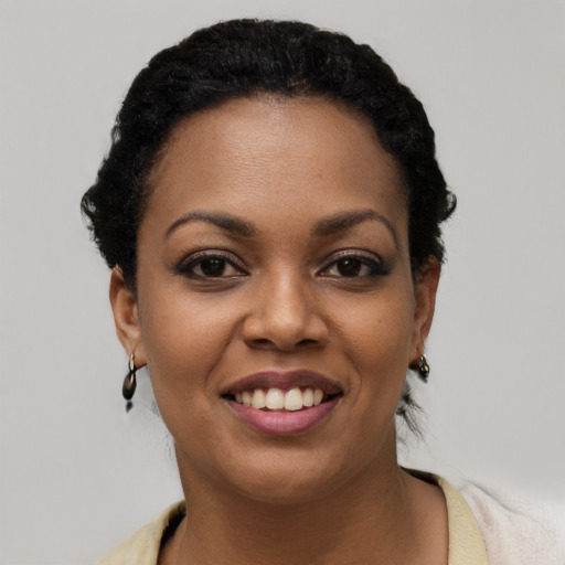Joyful black young-adult female with short  black hair and brown eyes