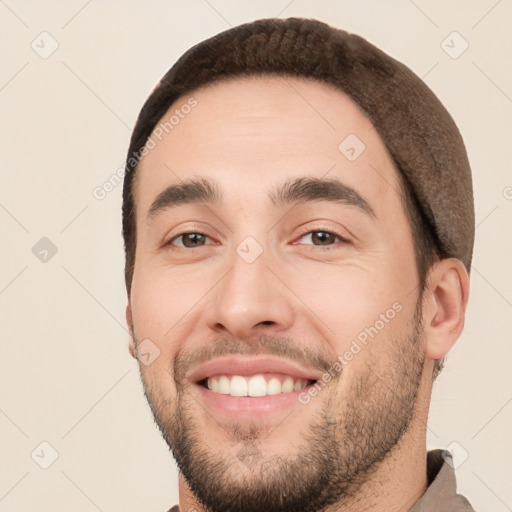 Joyful white young-adult male with short  black hair and brown eyes