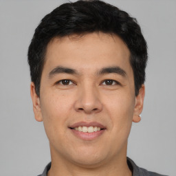 Joyful asian young-adult male with short  black hair and brown eyes