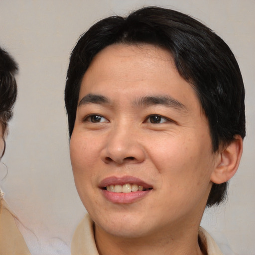 Joyful asian young-adult male with medium  brown hair and brown eyes