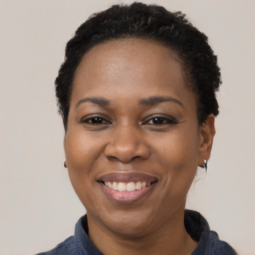 Joyful black adult female with short  black hair and brown eyes