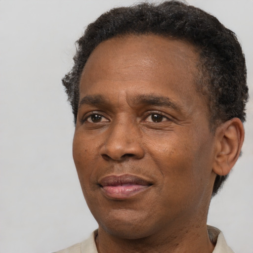 Joyful black adult male with short  brown hair and brown eyes