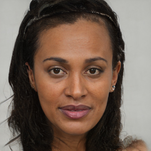 Joyful black young-adult female with long  brown hair and brown eyes