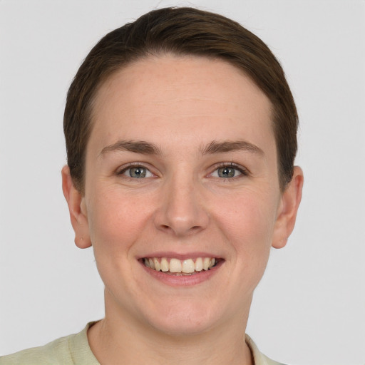 Joyful white young-adult female with short  brown hair and grey eyes