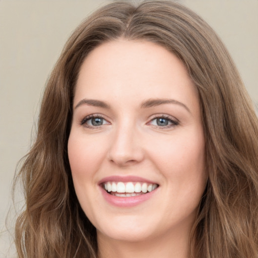 Joyful white young-adult female with long  brown hair and green eyes