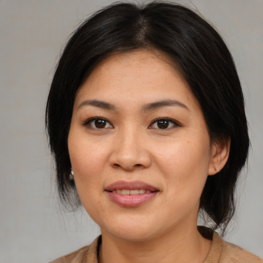Joyful asian young-adult female with medium  brown hair and brown eyes