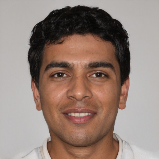 Joyful latino young-adult male with short  black hair and brown eyes