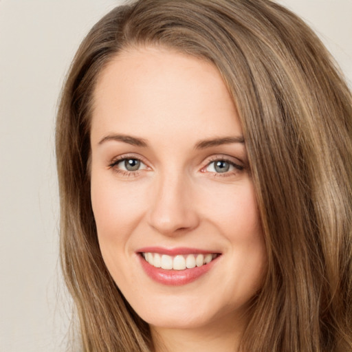 Joyful white young-adult female with long  brown hair and green eyes