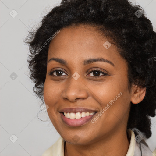 Joyful black young-adult female with long  brown hair and brown eyes