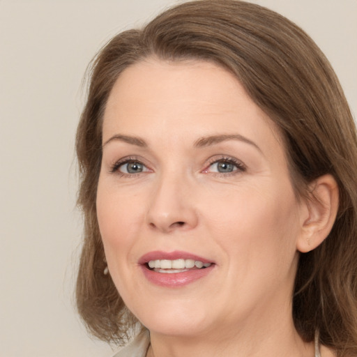 Joyful white adult female with medium  brown hair and brown eyes