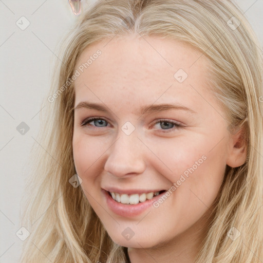 Joyful white young-adult female with long  brown hair and blue eyes