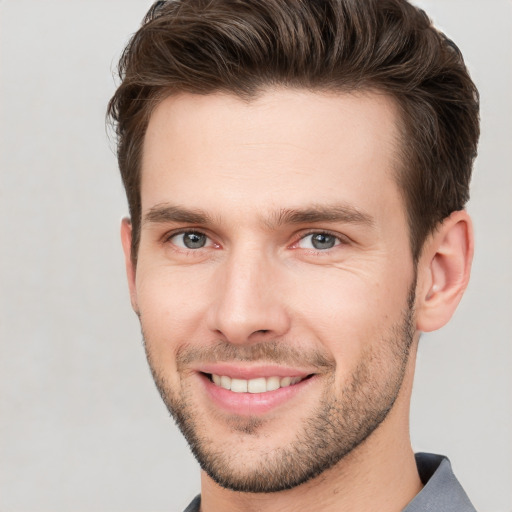 Joyful white young-adult male with short  brown hair and grey eyes